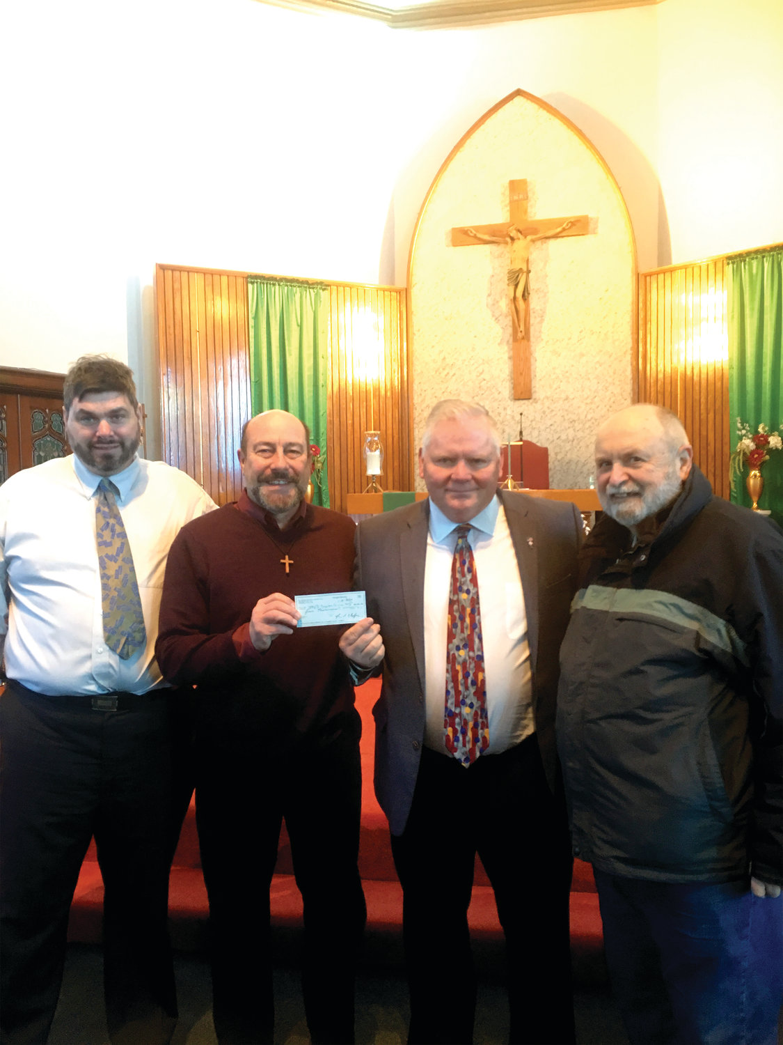 Lincoln Grand Knight, Ray Hedenskog, presents a check for $4000 to Matthew Perry, chairman of Special Religious Educational Development (SPRED), as part of the annual Knights of Columbus Tootsie Roll drive. The money will be used to support people with special needs in local parishes. From left, Peter Hamm, Matthew Perry, Raymond Hedenskog and Bud Gardner.